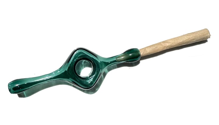 Une pipe en verre vert avec un filtre en papier brun.