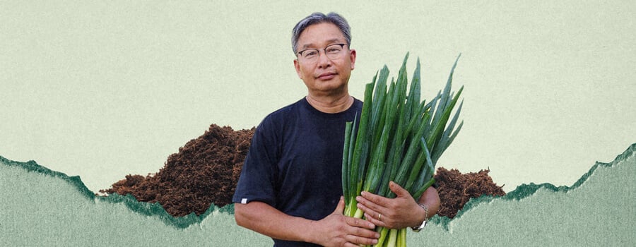 Un homme nommé Youngsang Cho tient une botte d'oignons verts. Il se tient devant un tas de terre.